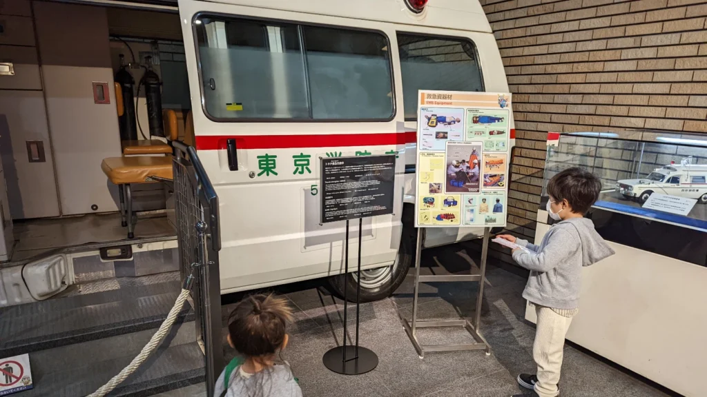 Luca & Nico exploring an ambulance exhibit at the Tokyo Fire Museum, one of the top free family activities in Tokyo.