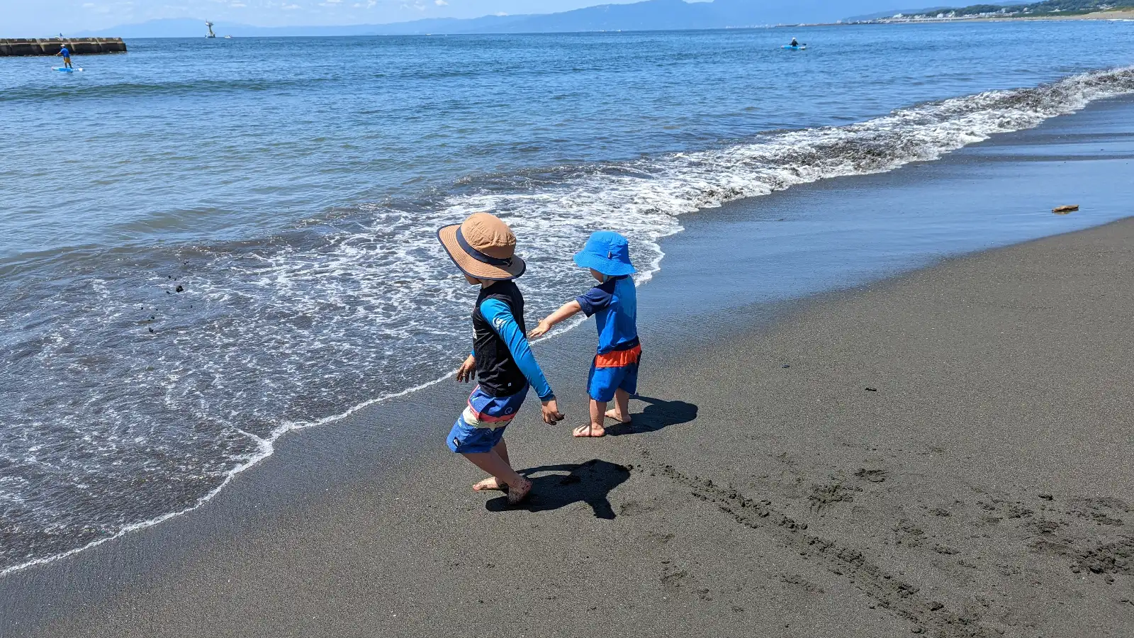 Children playing in the shallow waves at a family-friendly beach near Tokyo, a perfect swimming spot for kids and parents to enjoy together.