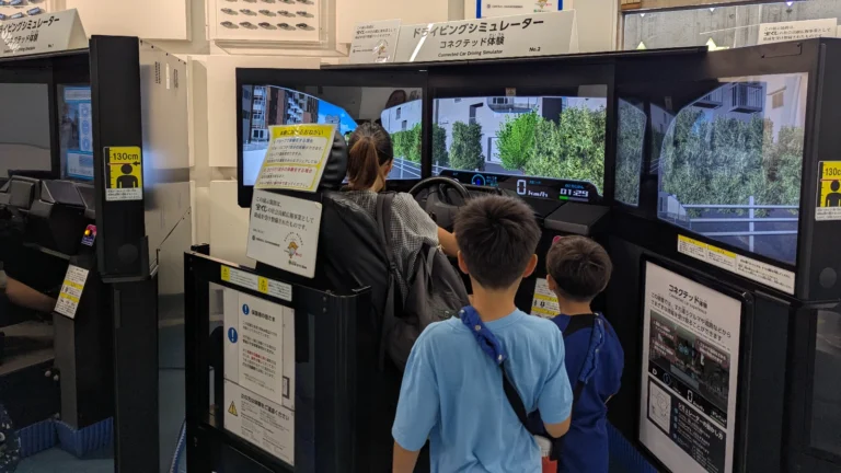 Luca & Nico watch mama test the driving simulator at the Tokyo Science and Technology Museum, a hands-on exhibit perfect for families.