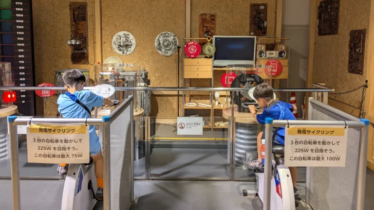 Luca & Nico pedal bikes to generate electricity at the Tokyo Science and Technology Museum in Chiyoda, Tokyo, learning about energy through play.