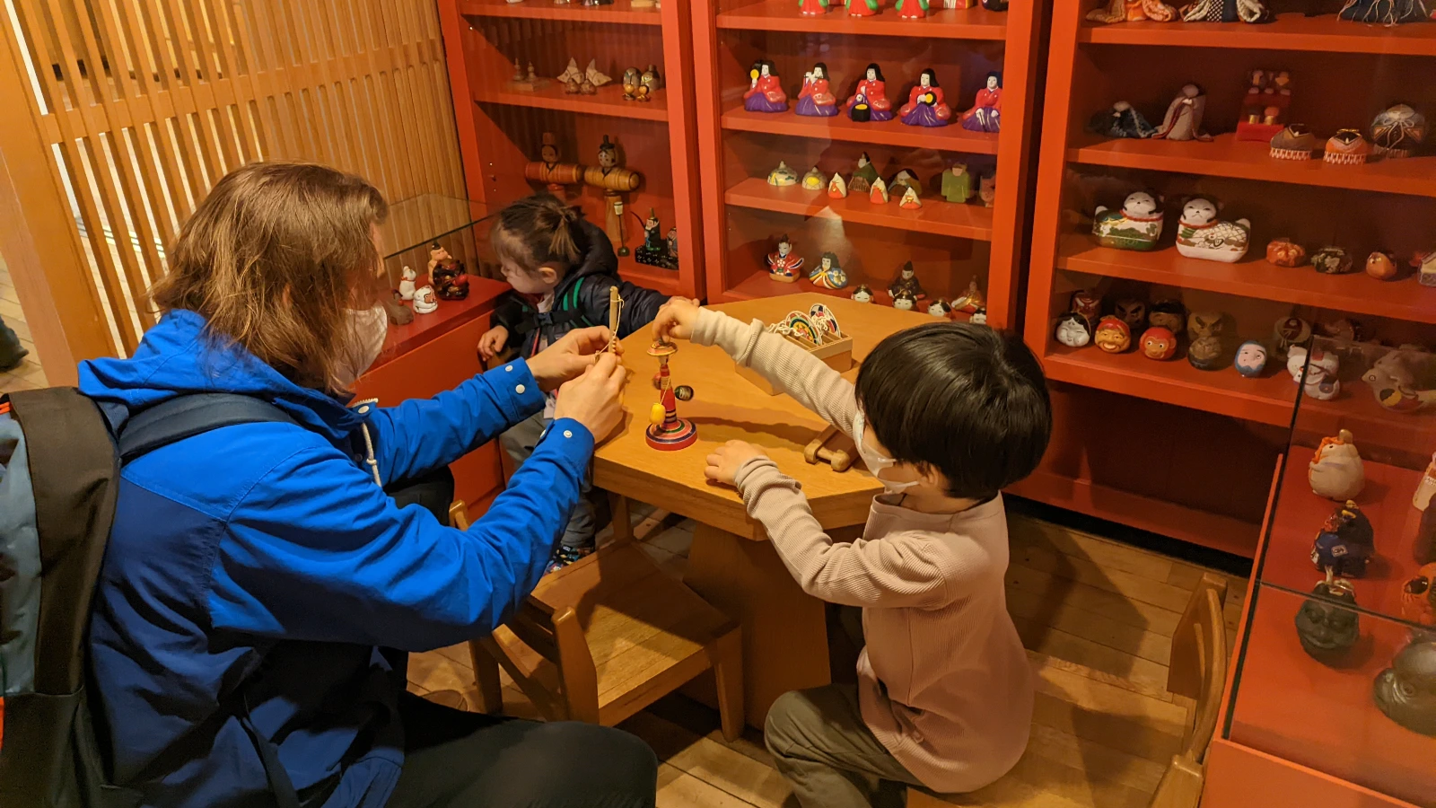 Children and parent exploring traditional Japanese toys at Tokyo Toy Museum in Shinjuku Tokyo.