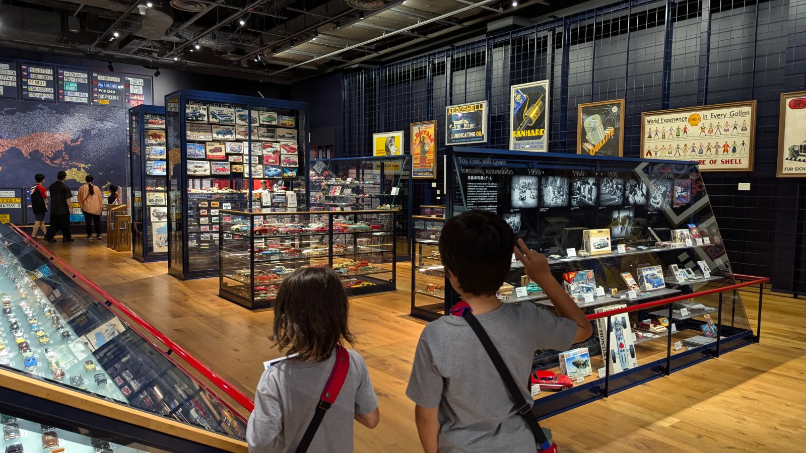 Luca and Nico browse cases of model cars, toys and vintage oil posters at the Toyota Automobile Museum in Nagakute, Aichi.