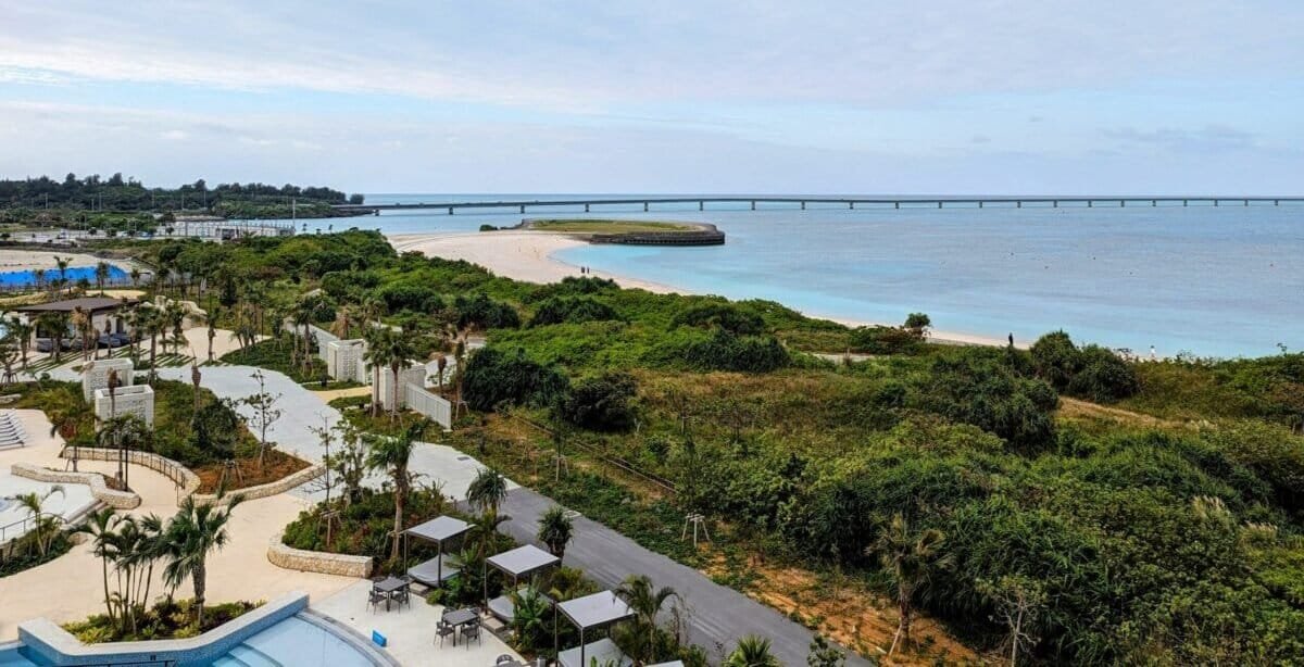 Stunning view of Miyakojima's (Miyako Island) tropical coastline and Yonaha Maehama Beach from the Hilton Miyakojima Resort, showcasing pristine waters and lush greenery, perfect for a family-friendly getaway.