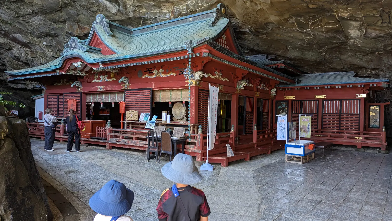 Children exploring Udo Shrine in Miyazaki, a colorful Japanese shrine built into a seaside cave.
