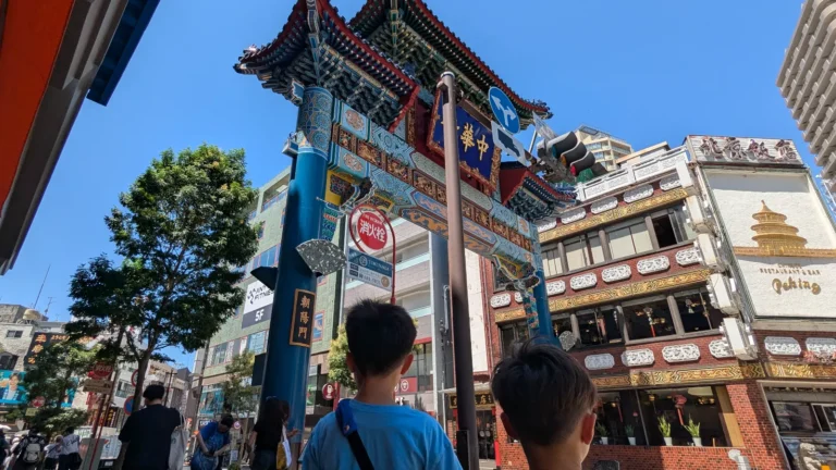 Luca and Nico standing beneath the colorful Choyo-mon gate in Yokohama Chinatown, exploring Japan’s largest Chinatown as a family-friendly adventure.