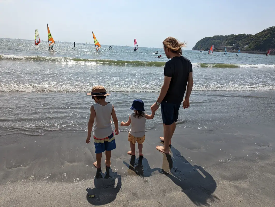 Luca & Nico stand in the sand at Zushi beach near Yokohama, showcasing outdoor adventures for families.