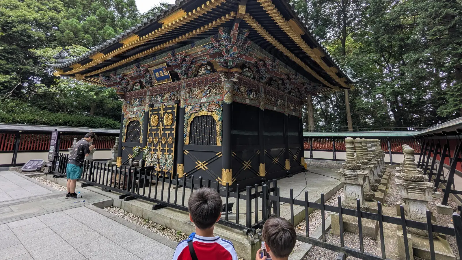 Children observe the detailed carvings and gold decorations of the Zuihoden mausoleum in Sendai, Japan, during a family visit to Date Masamune’s grave.
