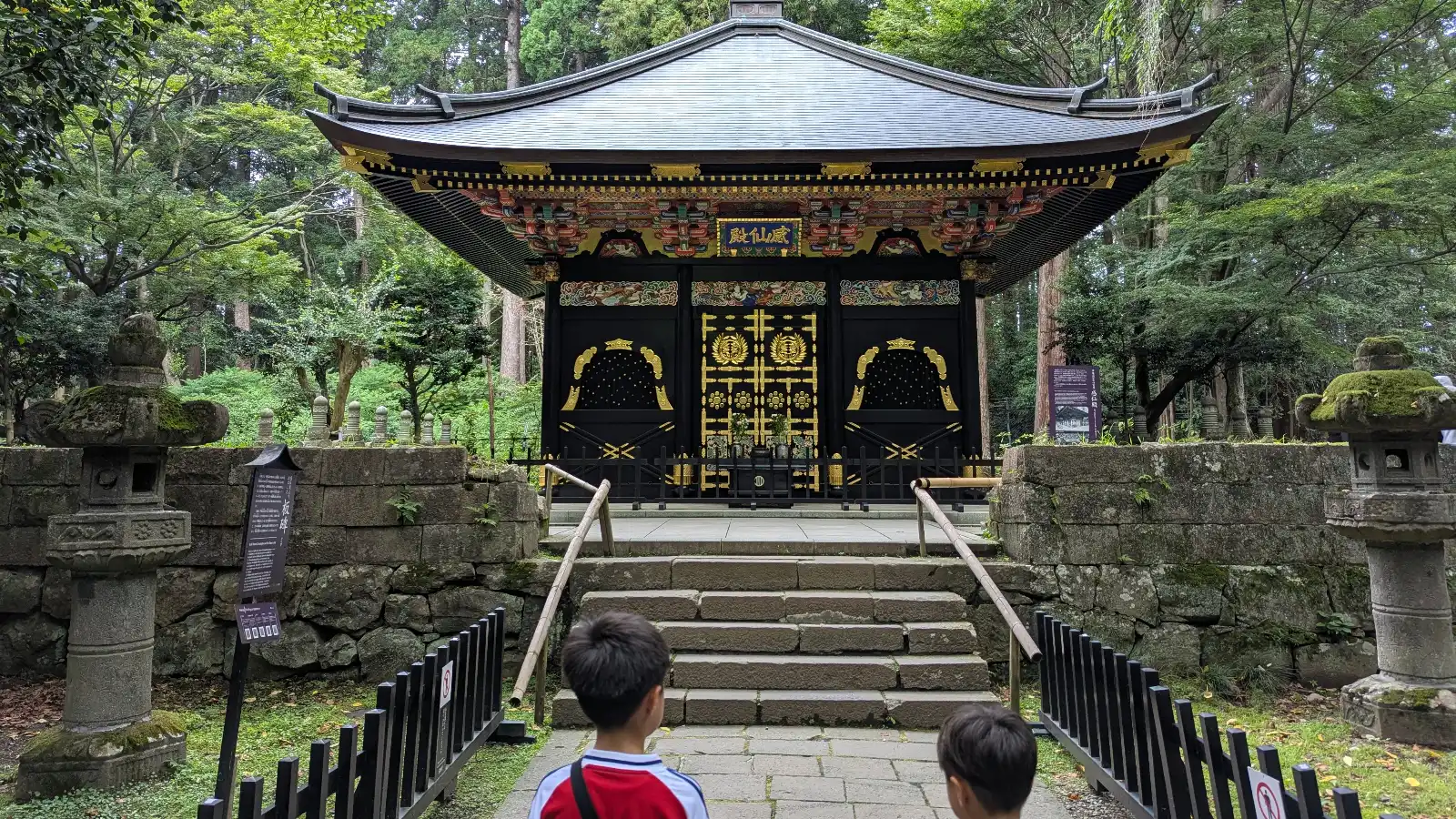 Children standing before the ornate Zuihoden Mausoleum of Date Masamune, a cultural highlight for families visiting Sendai.