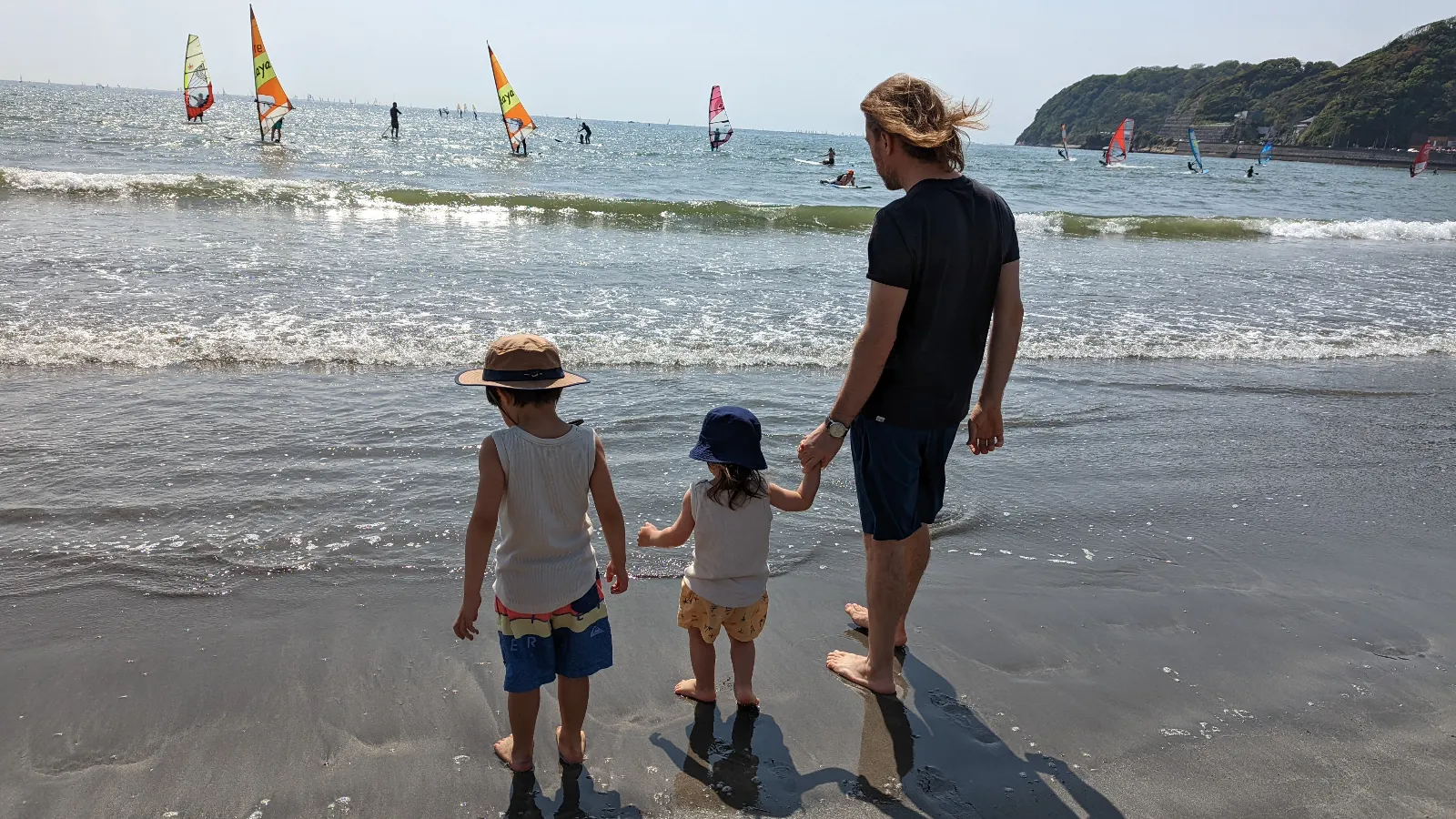 Luca & Nico standing with Papa at the edge of the water at Zushi Beach, one of the best kid-friendly public beaches near Tokyo for families